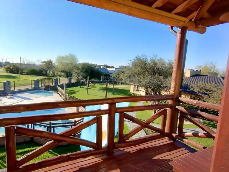 Balcón terraza con mesa y vista a la piscina